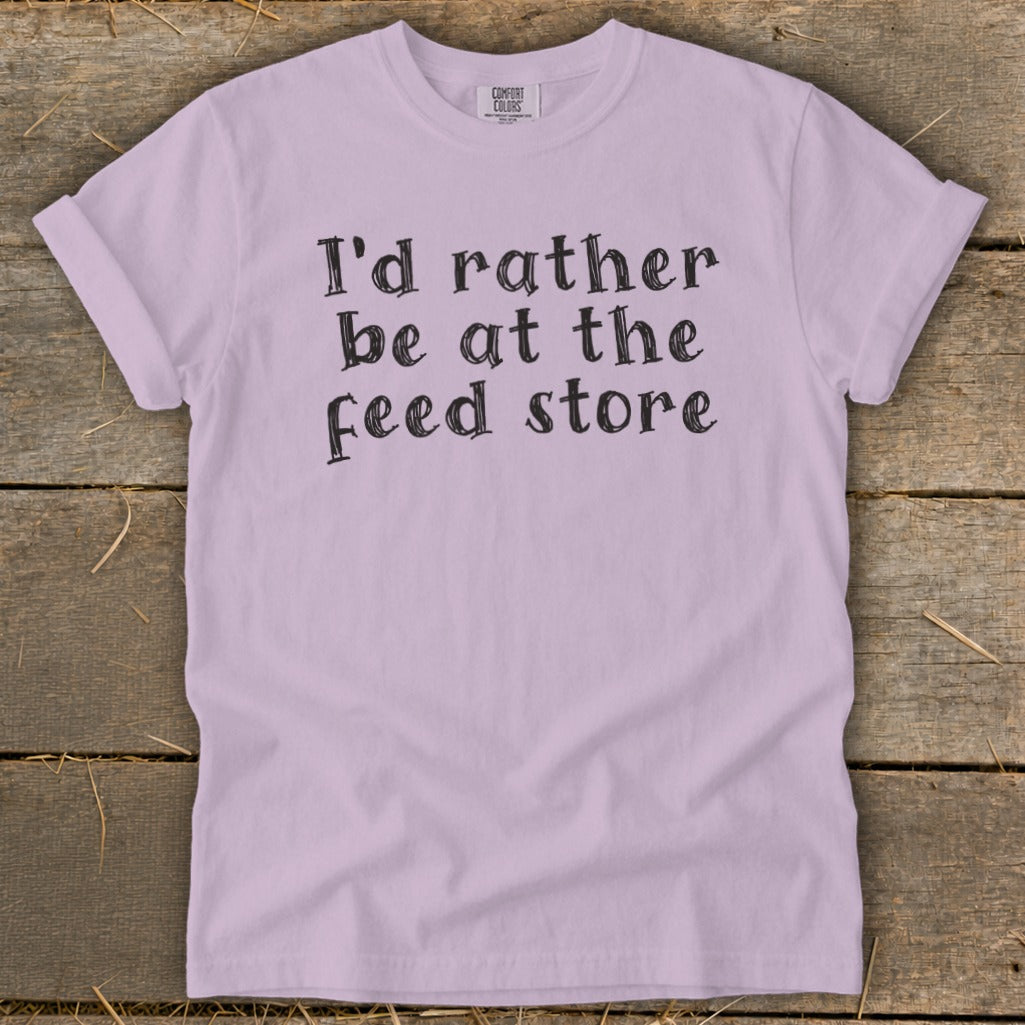 Light purple Comfort Colors t-shirt with "I'd rather be at the feed store" text.