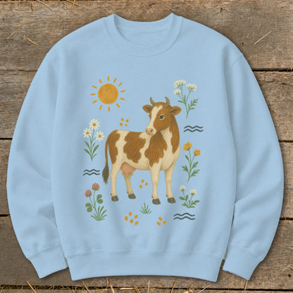 Light blue sweatshirt with a brown and white cow and floral graphics.