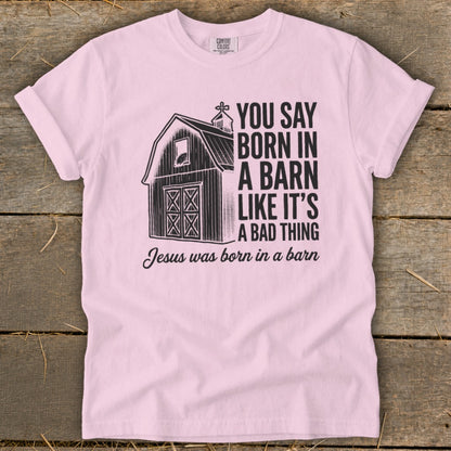 Pink t-shirt with barn graphic and text: "You Say Born In A Barn Like It's A Bad Thing. Jesus was born in a barn."