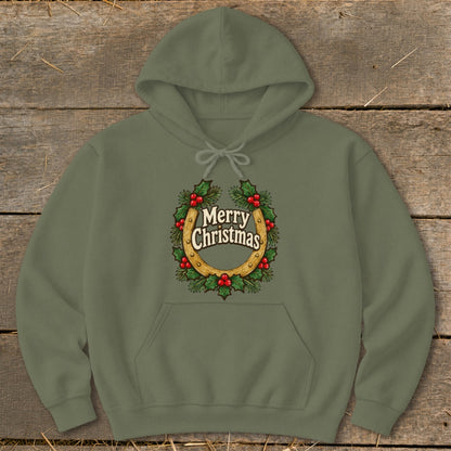 Olive green hoodie with a horseshoe and holly wreath graphic saying "Merry Christmas".