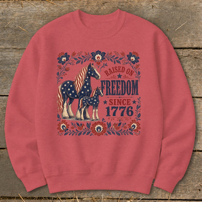 Crewneck sweatshirt with horses and "Raised on Freedom Since 1776" text.