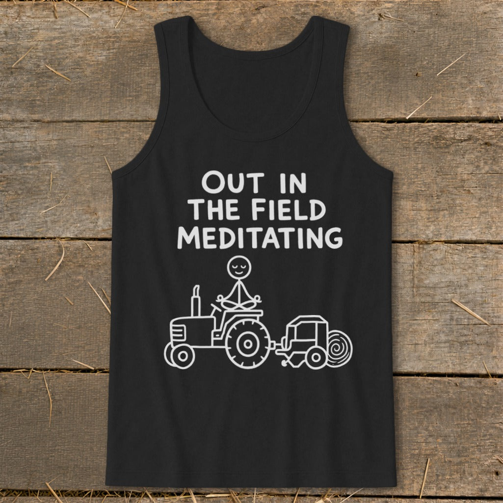 Black tank top with "OUT IN THE FIELD MEDITATING" text and a stick figure on a tractor.