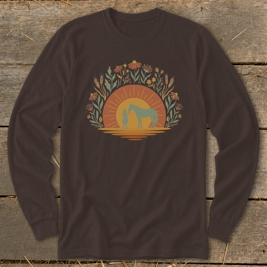Silhouette of a person with a horse against a sunset and floral border.