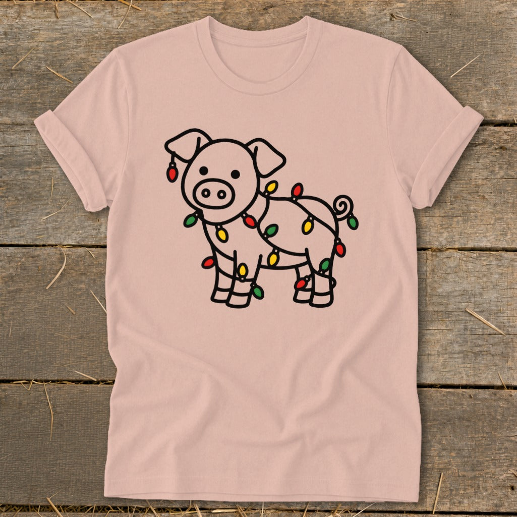 A pink crewneck t-shirt featuring a cute cartoon pig tangled in colorful Christmas lights.