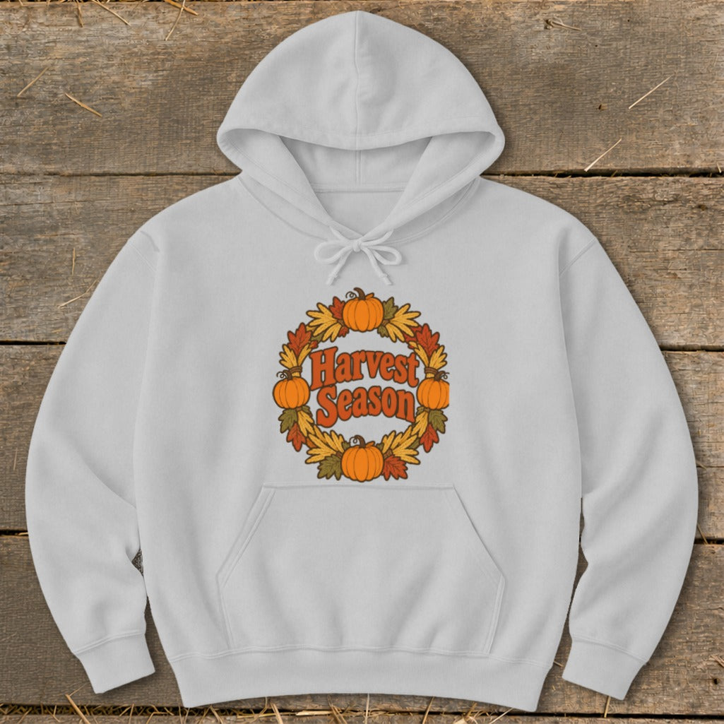 White hoodie with "Harvest Season" text in a circular pumpkin and leaf design.