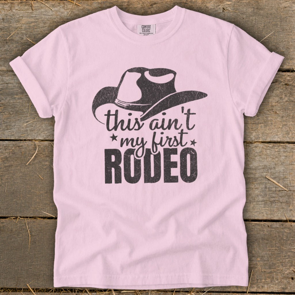Pink t-shirt with a cowboy hat graphic and text "this ain't my first RODEO".