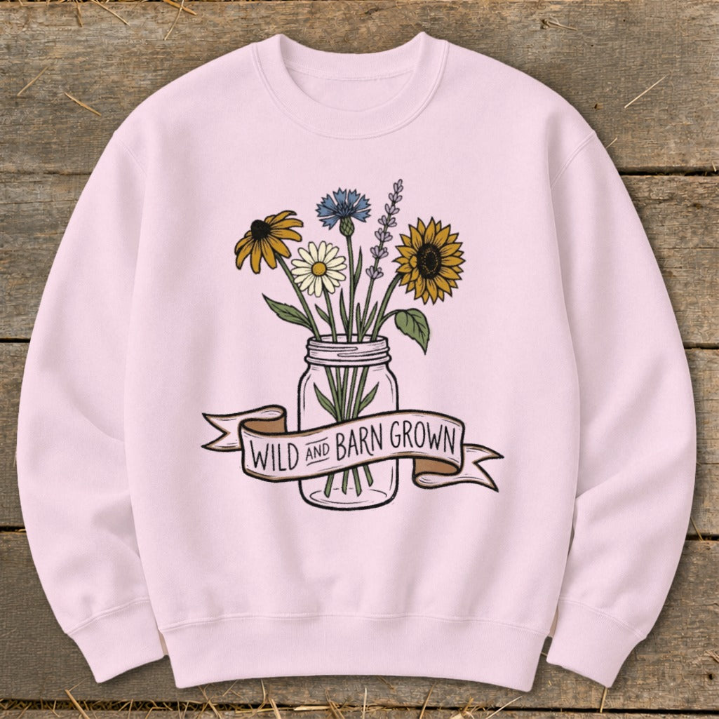 Pink sweatshirt with wildflowers in a mason jar and banner reading "WILD AND BARN GROWN".