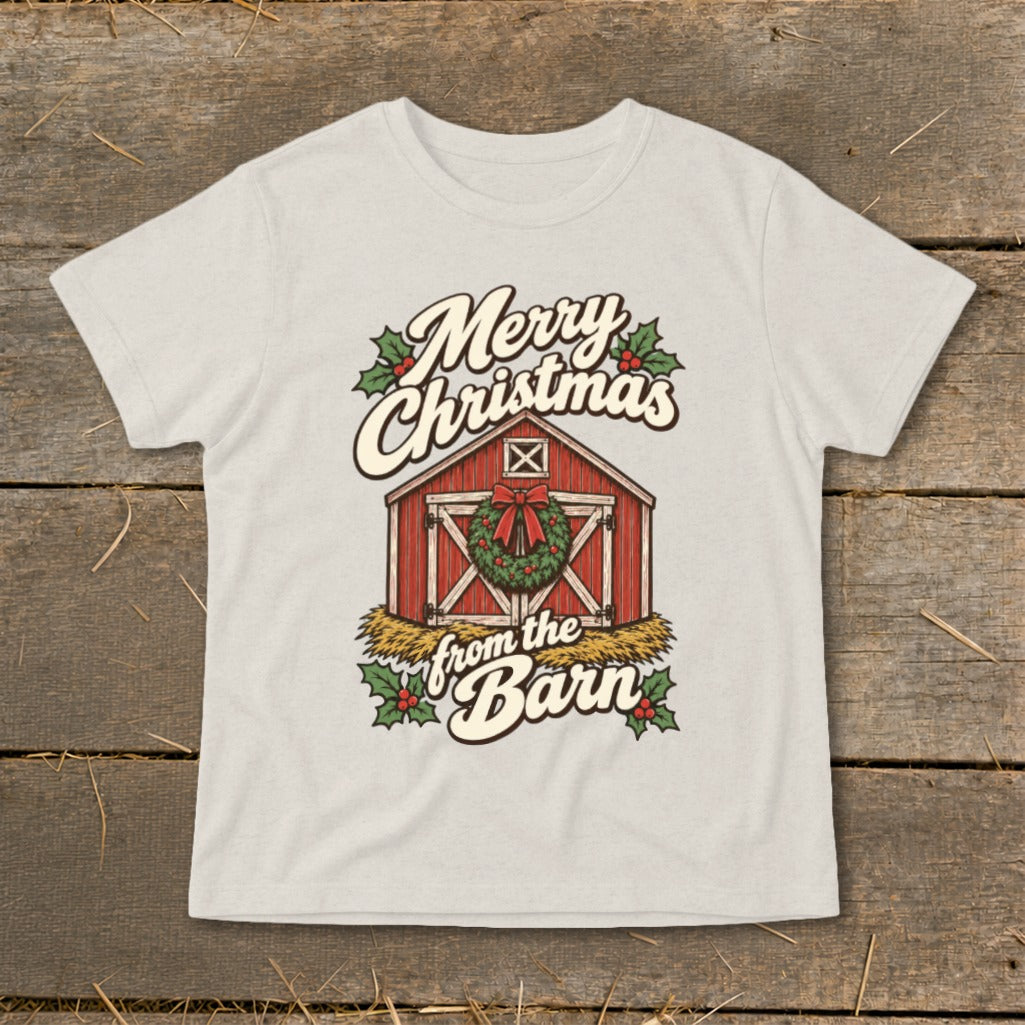 A light-colored t-shirt with a vintage Christmas graphic of a red barn, wreath, and holiday text.