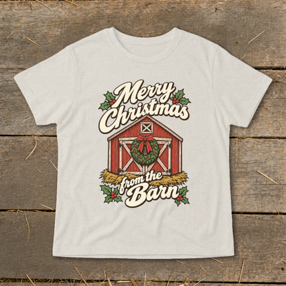 A light-colored t-shirt with a vintage Christmas graphic of a red barn, wreath, and holiday text.