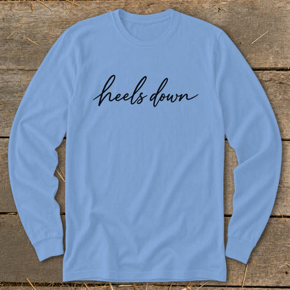 Light blue long sleeve shirt with "heels down" written in black cursive.