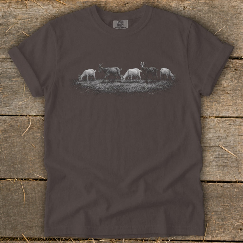 T-shirt with a graphic of five goats grazing in a field.