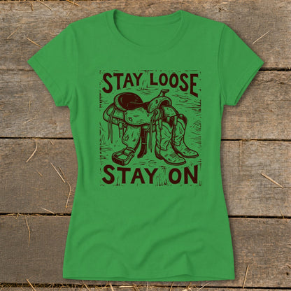 Green t-shirt with brown graphic of saddle and boots, text "STAY LOOSE STAY ON".