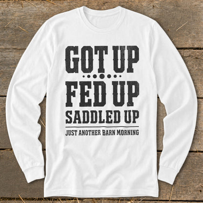White long-sleeve shirt with black text reading "GOT UP FED UP SADDLED UP JUST ANOTHER BARN MORNING".