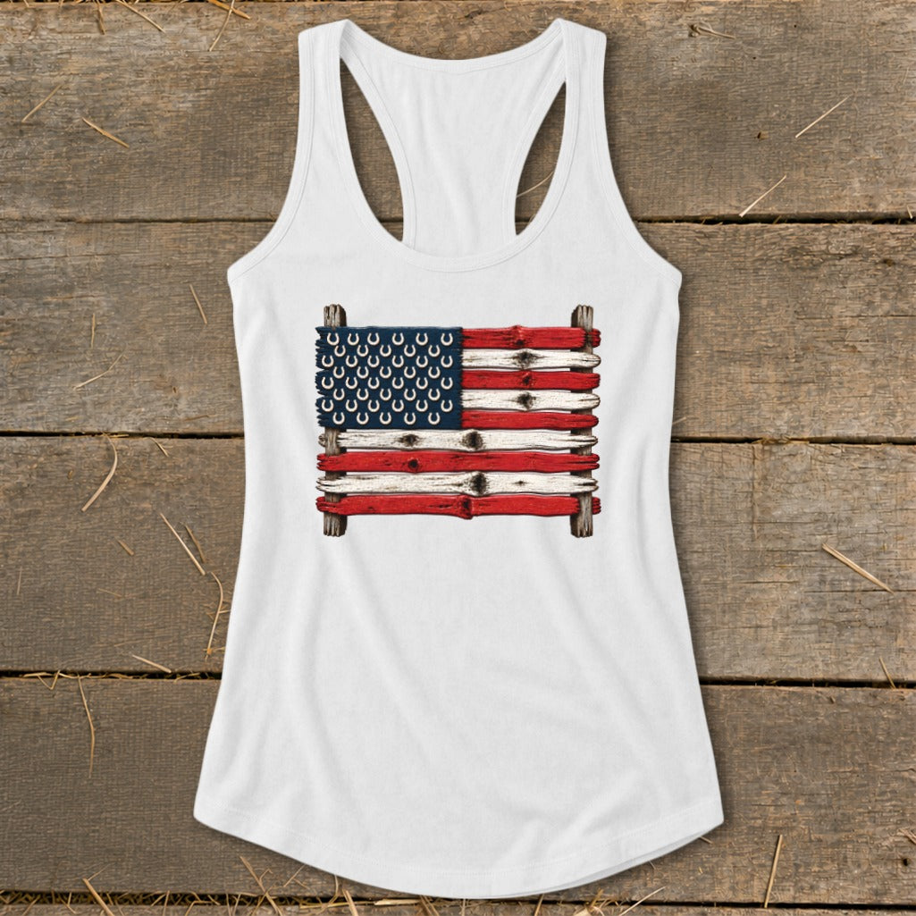 White women's racerback tank top featuring a rustic American flag graphic made of wooden planks and horseshoes.