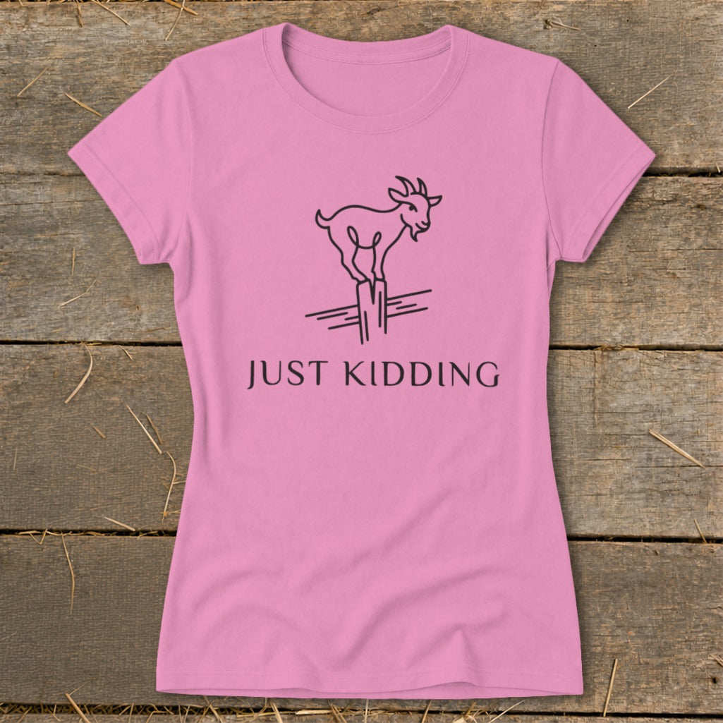 Pink t-shirt with a black line drawing of a goat on a post and the text "JUST KIDDING".