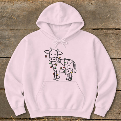 Pink hoodie with a line drawing of a cow wrapped in colorful holiday lights.