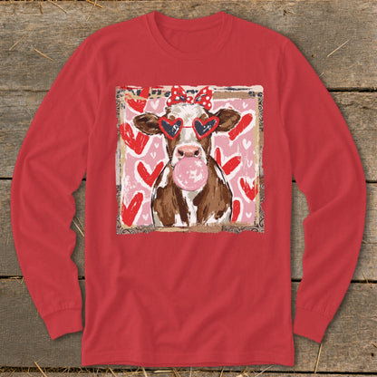 Cow wearing heart sunglasses and red bow blows pink bubblegum, with hearts background.