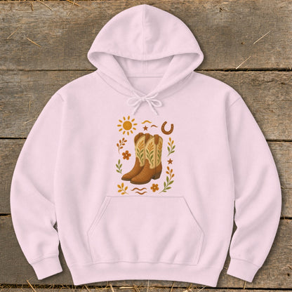 Light pink hoodie with a central graphic of cowboy boots surrounded by western motifs.