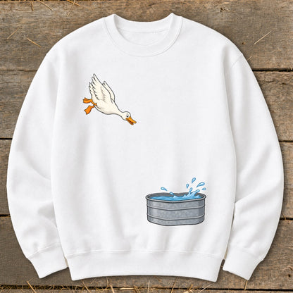 White sweatshirt with a cartoon duck flying towards a metal water trough.