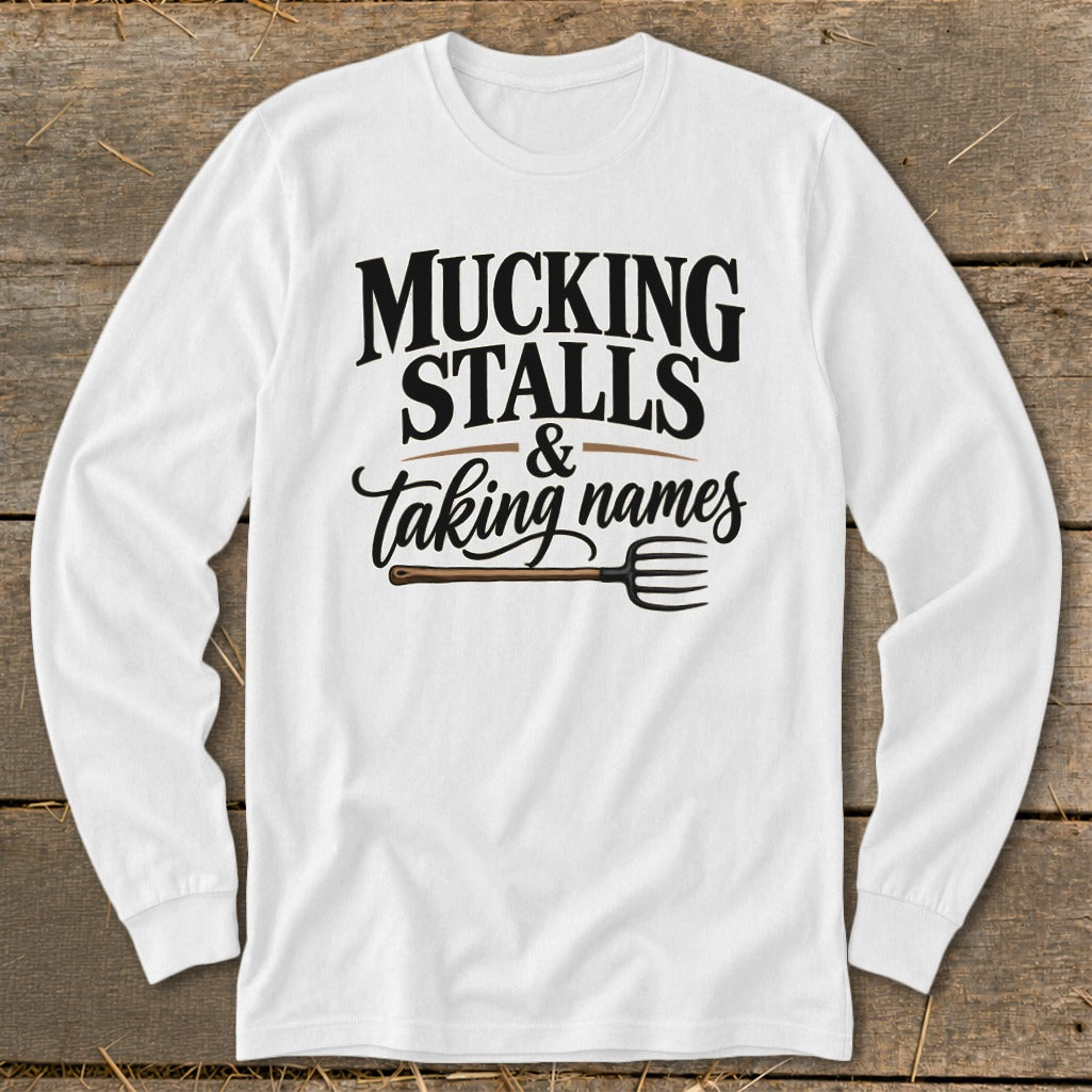White long sleeve shirt with "Mucking Stalls & Taking Names" text and a pitchfork graphic.