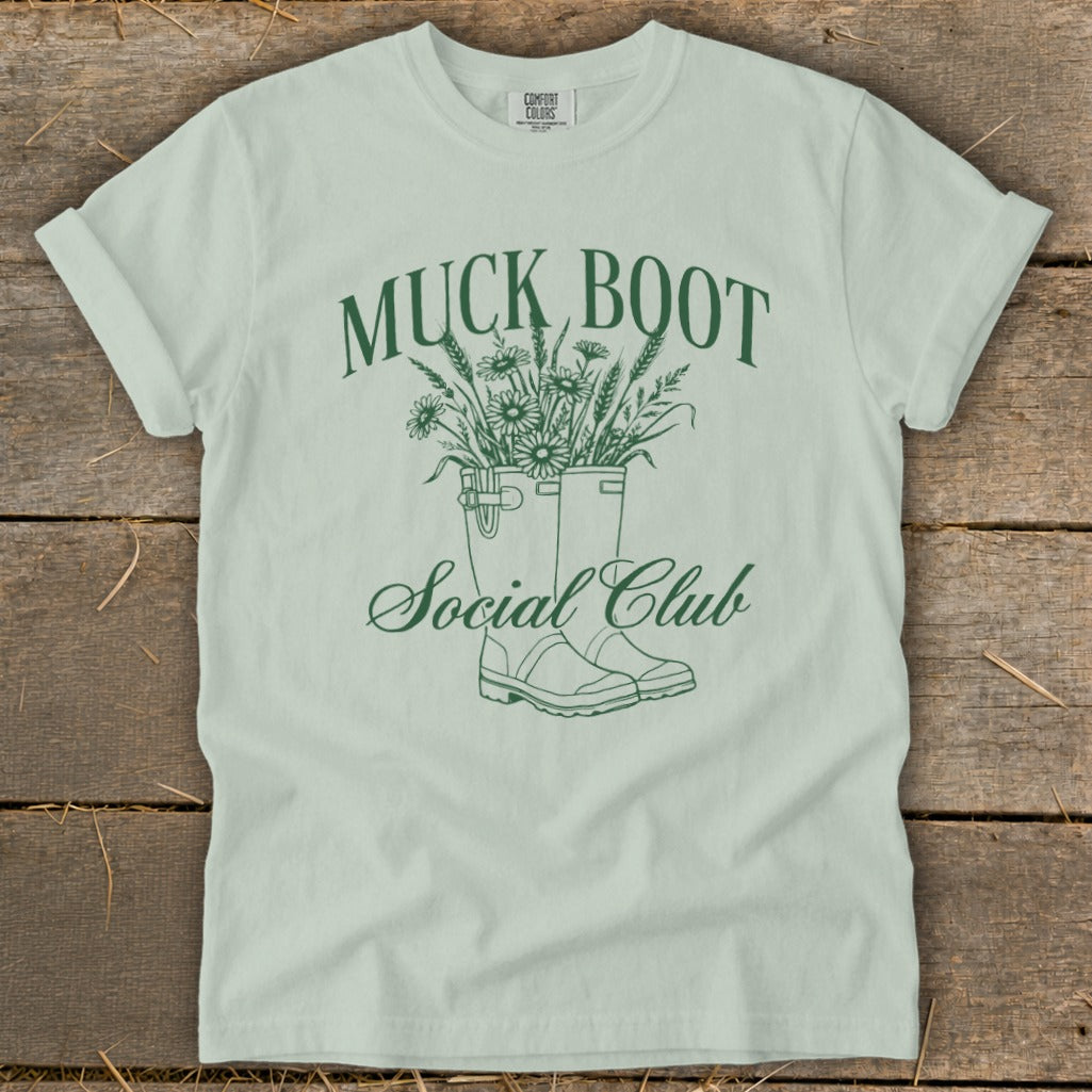 Light green t-shirt with green "Muck Boot Social Club" text and floral design.