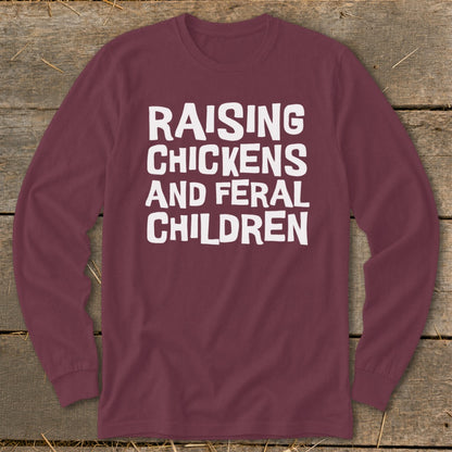 Maroon long-sleeve shirt with white text "Raising Chickens and Feral Children."
