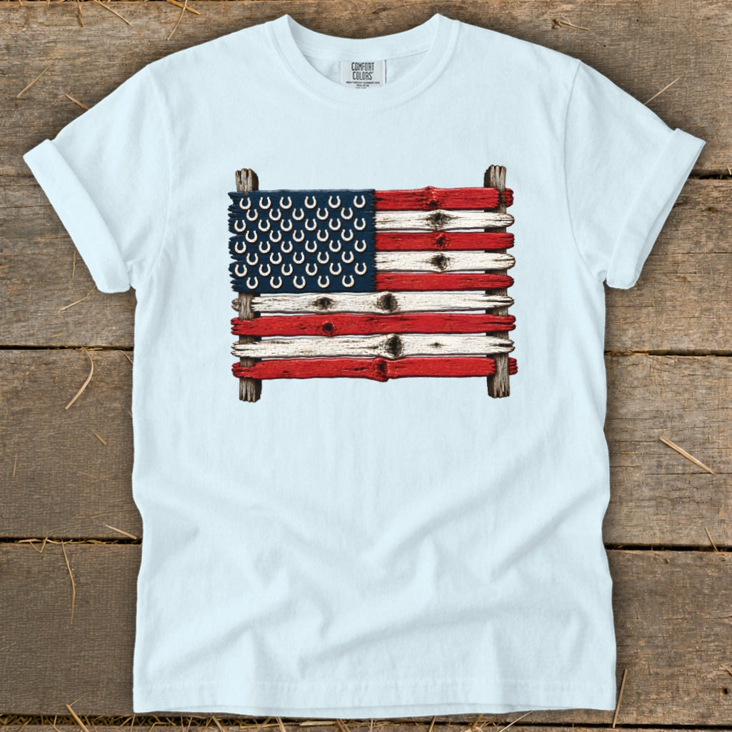 Light blue t-shirt featuring a graphic of an American flag made of painted wooden planks and horseshoes.