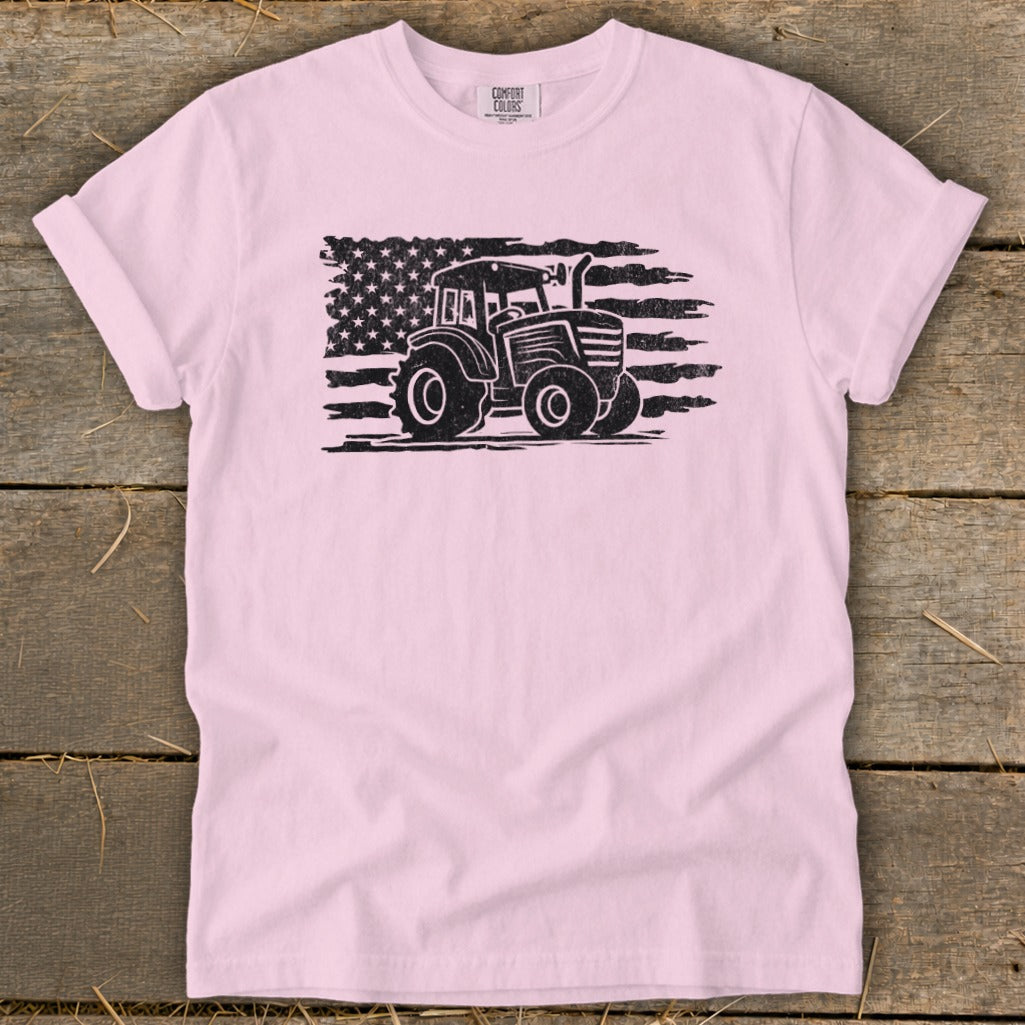 Pink t-shirt with black distressed tractor graphic superimposed on American flag.