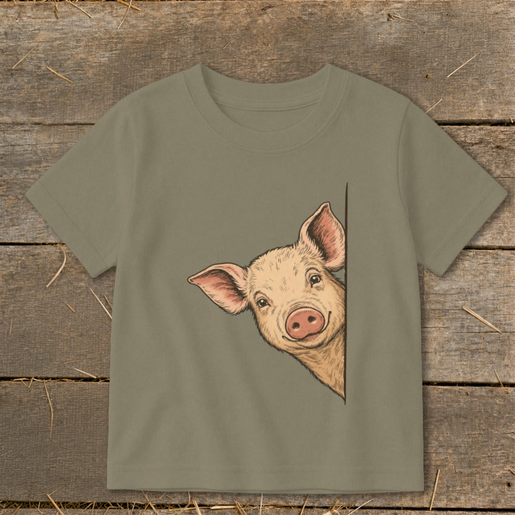 T-shirt with a drawing of a pig peeking from behind the side.