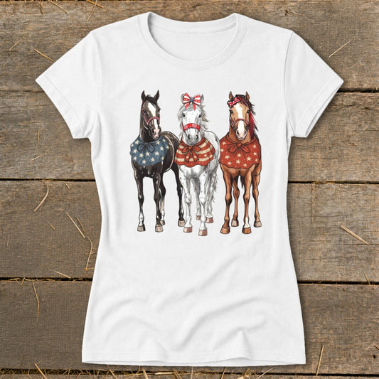 Three horses, black, white, and brown, wear patriotic bandanas and bows.