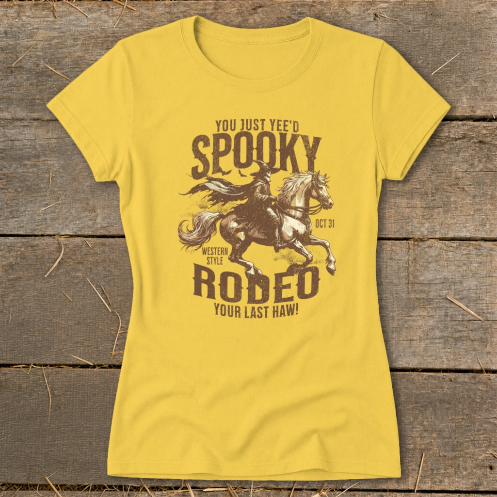 Yellow t-shirt with "Spooky Rodeo" graphic featuring a cowboy on a horse and bats.