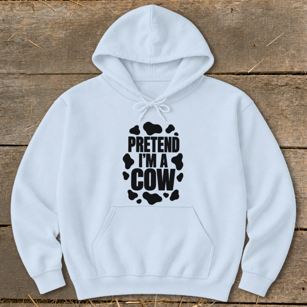 White hoodie with black "Pretend I'm a Cow" text and cow spots.