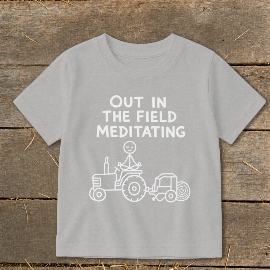 Light gray t-shirt with "Out in the Field Meditating" and a stick figure meditating on a tractor.