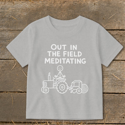 Light gray t-shirt with "Out in the Field Meditating" and a stick figure meditating on a tractor.