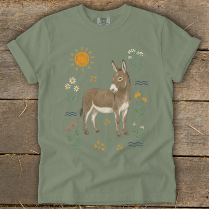 Donkey graphic with sun, flowers, and water on a sage green t-shirt.