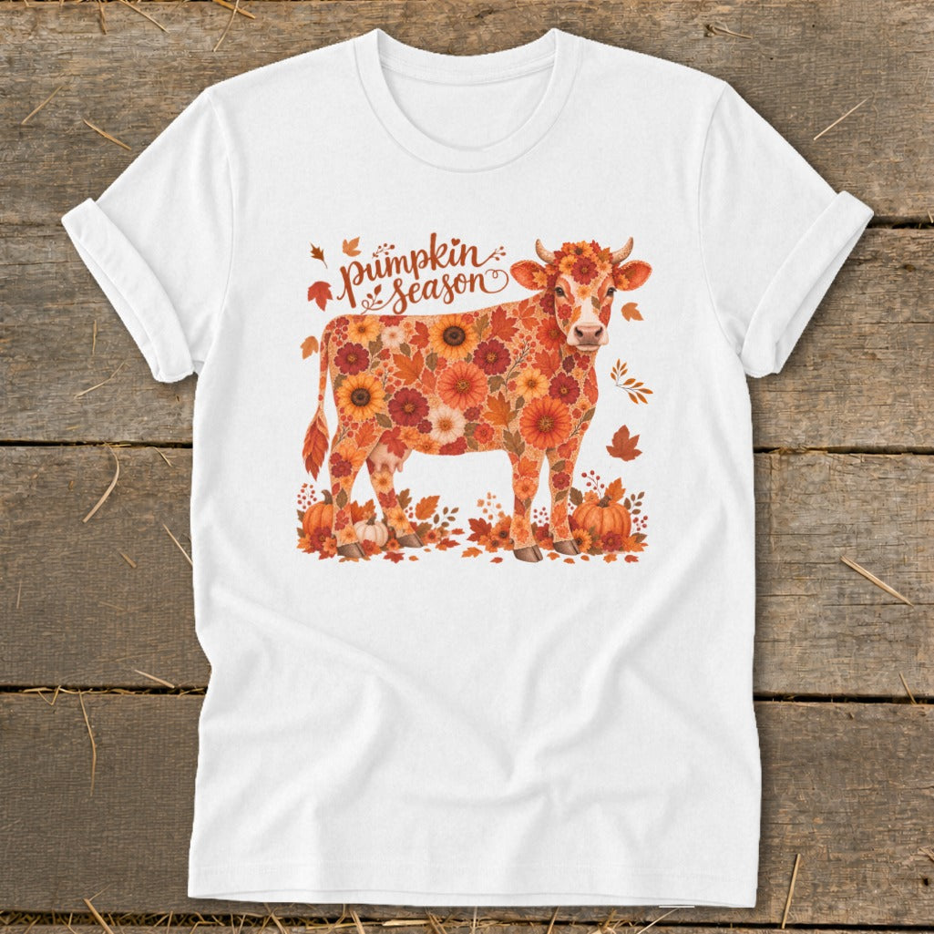 White t-shirt with a cow illustration covered in autumn leaves and flowers, reading "Pumpkin Season".