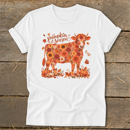 White t-shirt with a cow illustration covered in autumn leaves and flowers, reading "Pumpkin Season".