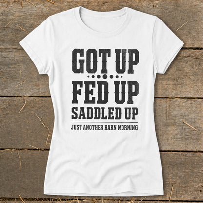 White t-shirt with black text: "GOT UP FED UP SADDLED UP JUST ANOTHER BARN MORNING".