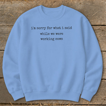 Light blue crewneck sweatshirt with "I'm sorry for what I said while we were working cows" text.