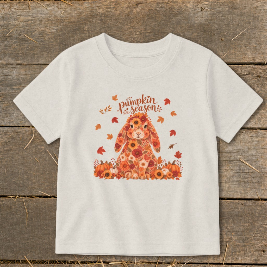 T-shirt with floral bunny and "Pumpkin Season" text, surrounded by autumn leaves and pumpkins.