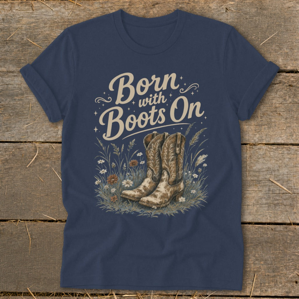 Navy t-shirt with graphic "Born with Boots On" and cowboy boots in grass.