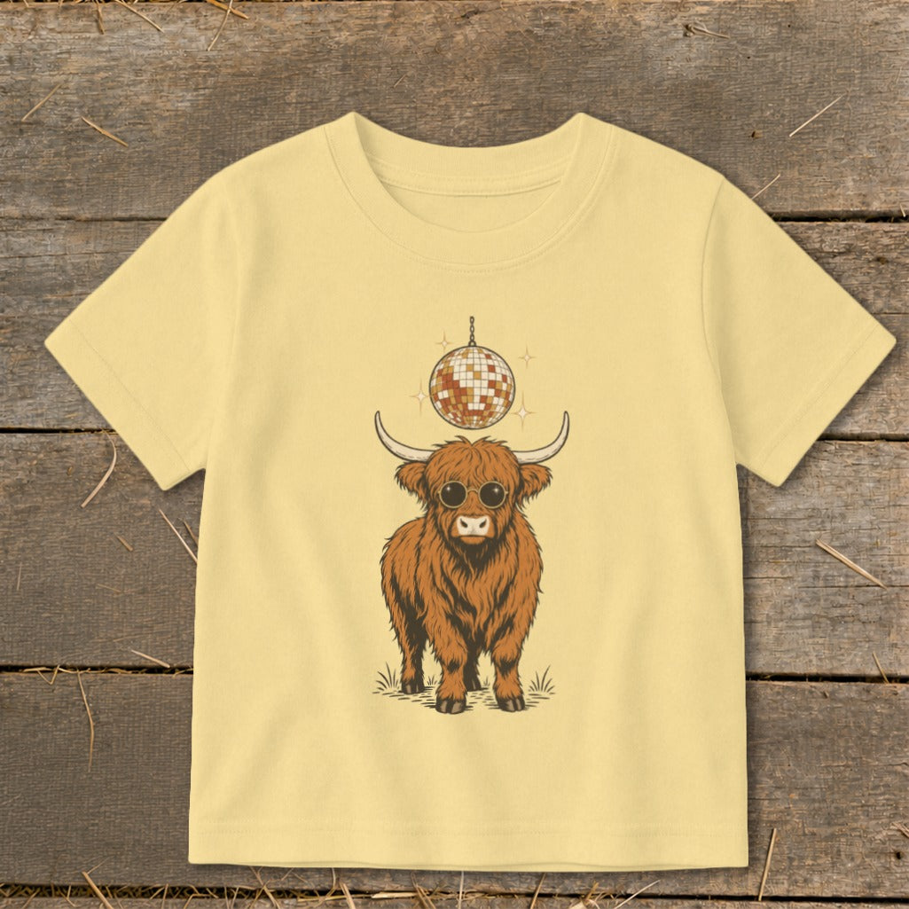 Fluffy Highland cow wearing sunglasses with a disco ball above.