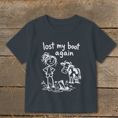 Dark grey t-shirt featuring a white graphic of a sad girl standing next to a cow and a muddy boot, with the text "lost my boot again."