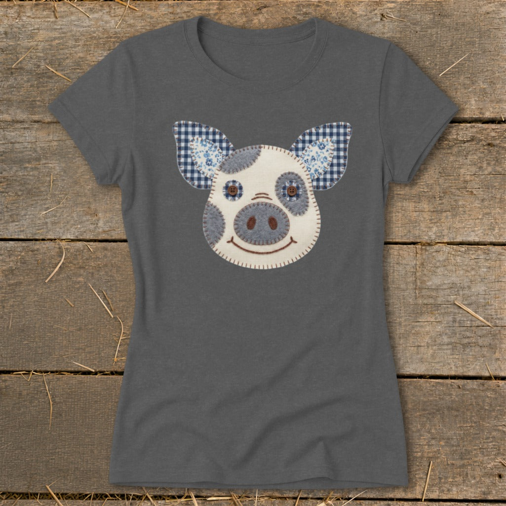 Dark grey t-shirt with a fabric applique of a pig's face with blue and white checkered ears.