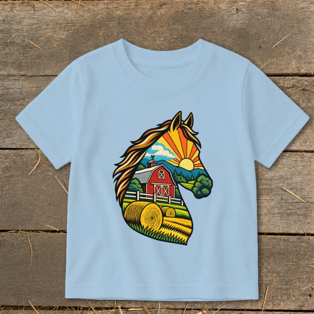 A light blue t-shirt with a graphic of a horse head silhouette filled with a farm landscape illustration.