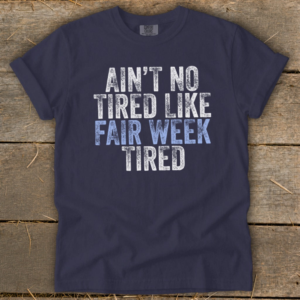 Navy t-shirt with text "Ain't No Tired Like Fair Week Tired".