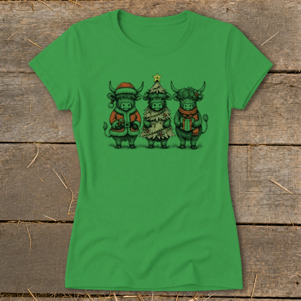 Three Highland cows dressed for Christmas: one in Santa suit, one as a tree, one holding a gift.