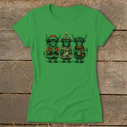 Three Highland cows dressed for Christmas: one in Santa suit, one as a tree, one holding a gift.