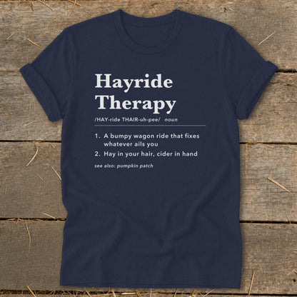 Navy t-shirt with "Hayride Therapy" definition, describing it as a wagon ride and hay in hair with cider.