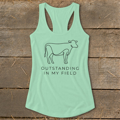 Mint green tank top with black line art cow and text "OUTSTANDING IN MY FIELD".
